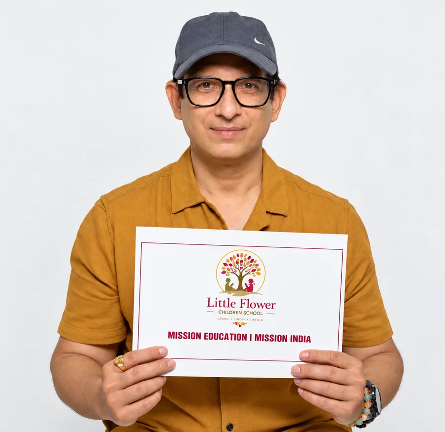 Sharman Joshi holding a Little Flower Children School sign